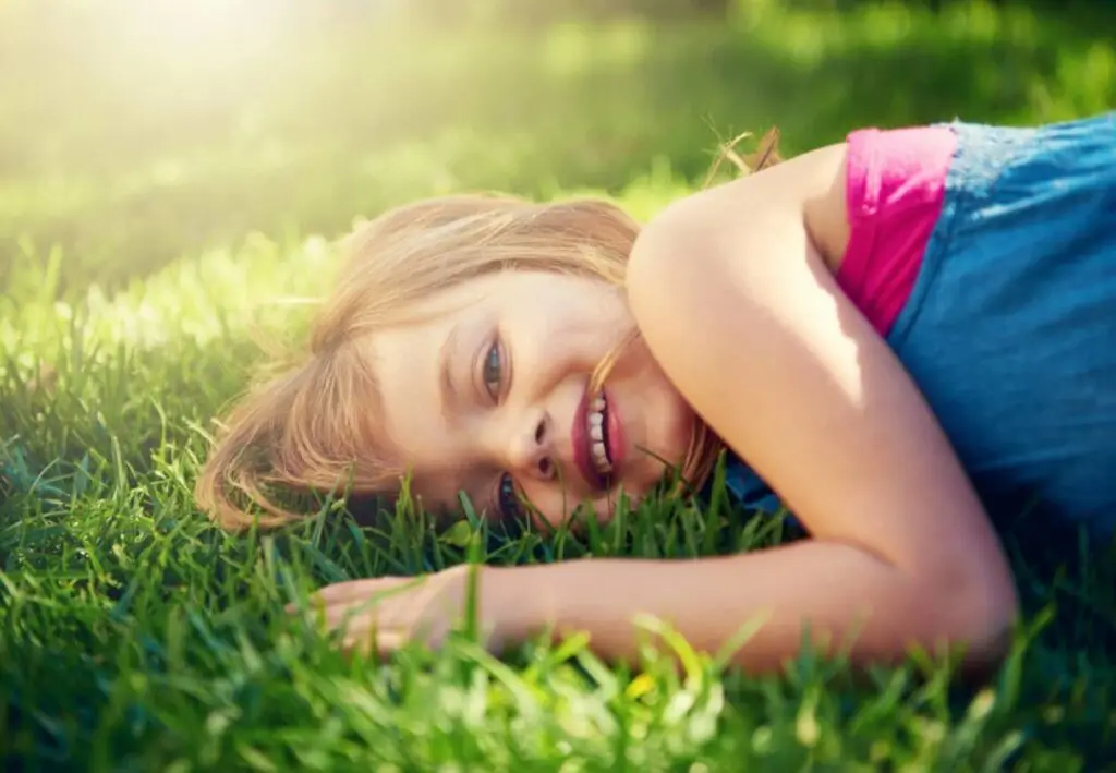 young girl laying in grass